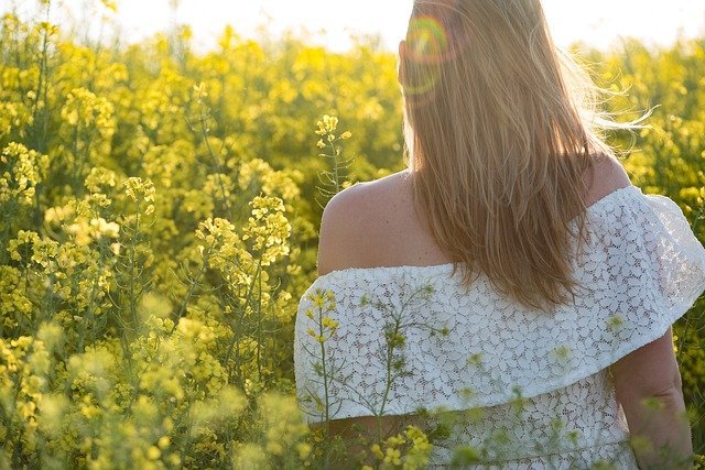 a girl taking sunlight in a field of flowers