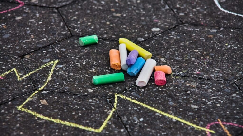 Colorful chalks lying on the floor with some lines drawn around