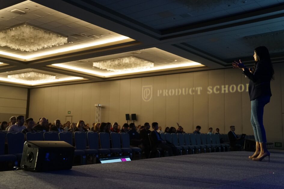 People listening to a lady giving a speech on the stage