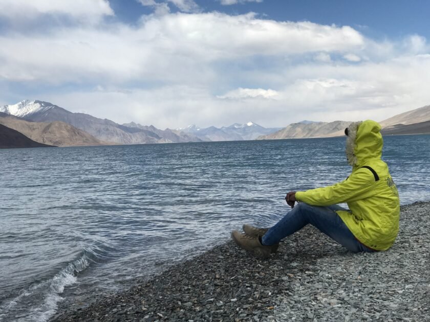 A girl sitting on a seashore alone