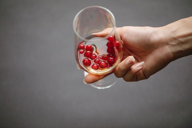 A hand holding glass of alcohol